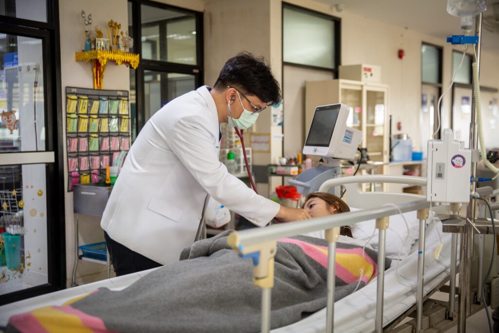 doctor examining patient in hospital bed